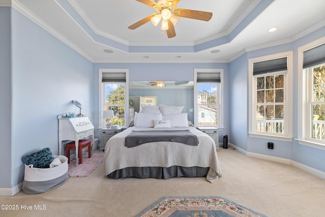 carpeted bedroom with crown molding, ceiling fan, and a tray ceiling