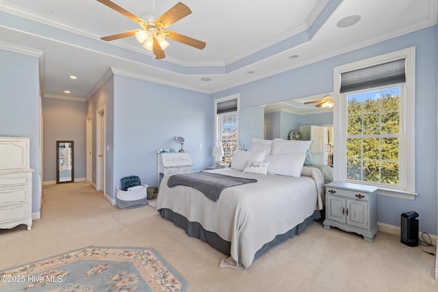 bedroom featuring ceiling fan, light colored carpet, ornamental molding, and a raised ceiling