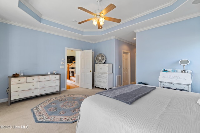 carpeted bedroom featuring crown molding, ceiling fan, and a tray ceiling