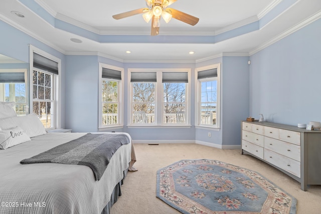 bedroom featuring ornamental molding, light carpet, ceiling fan, and a tray ceiling