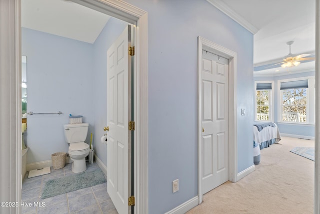 hallway featuring light colored carpet and ornamental molding