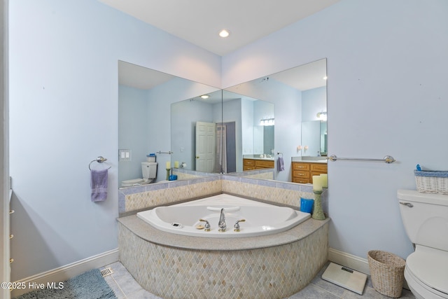 bathroom featuring vanity, tile patterned floors, tiled bath, and toilet