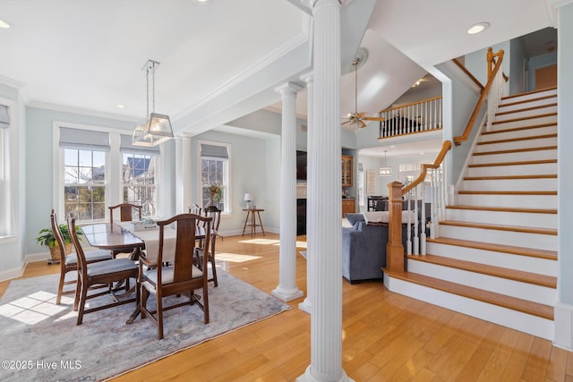 dining space featuring ornate columns, crown molding, ceiling fan, and light wood-type flooring