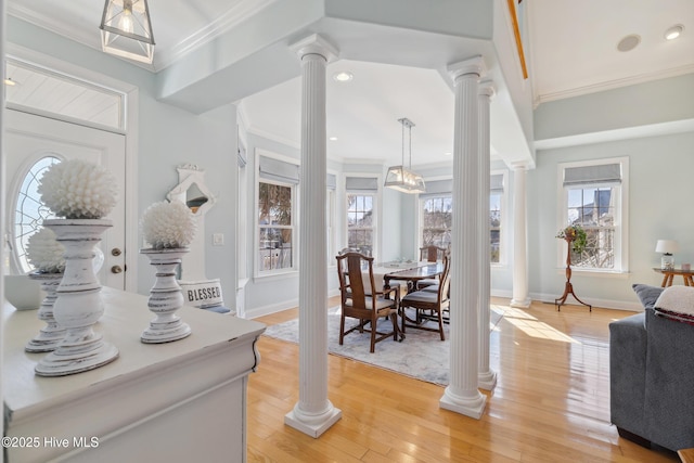 entrance foyer featuring ornamental molding and decorative columns