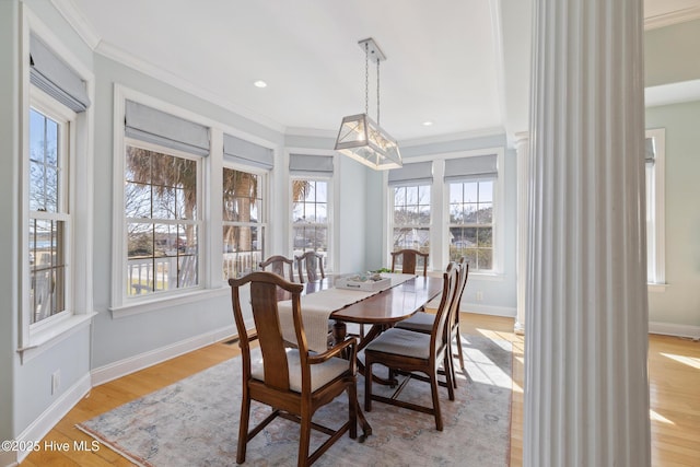 dining space featuring crown molding and light hardwood / wood-style floors