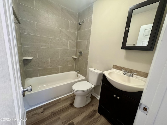 full bathroom with tiled shower / bath, vanity, toilet, and hardwood / wood-style floors