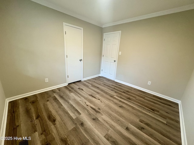 spare room with hardwood / wood-style floors and crown molding