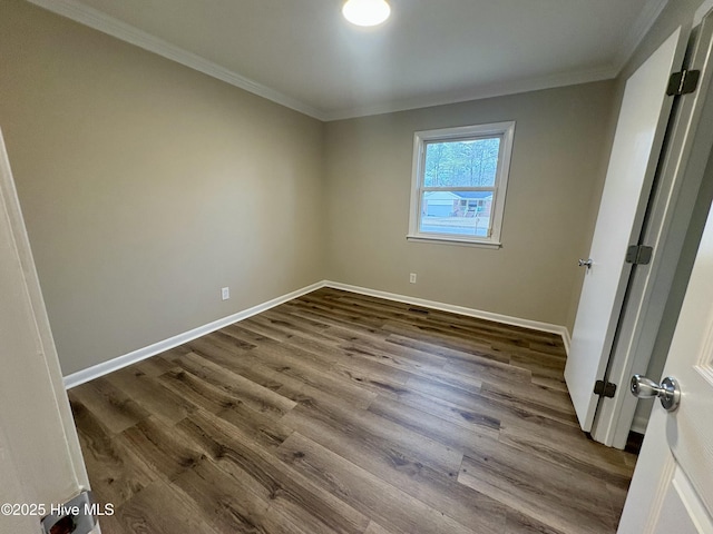 empty room featuring wood-type flooring and crown molding