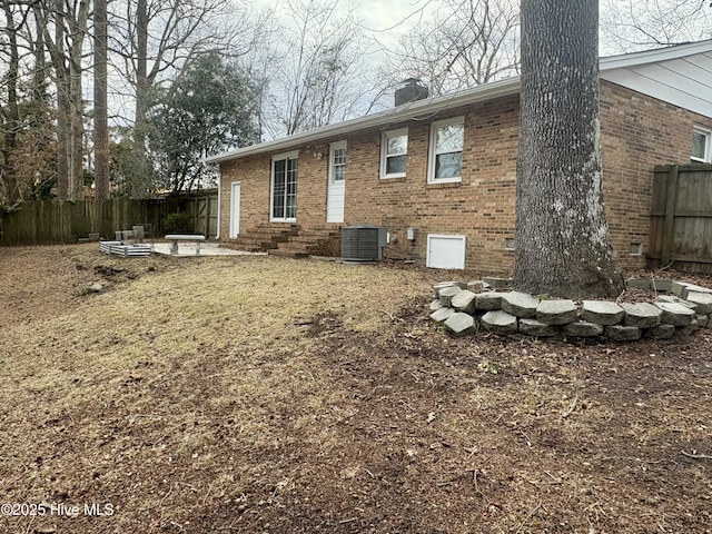 rear view of property with cooling unit and a patio area