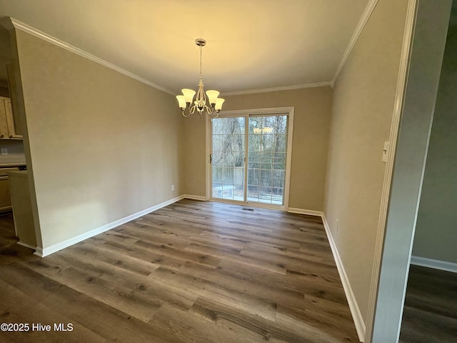 unfurnished dining area featuring dark wood-type flooring, ornamental molding, and an inviting chandelier