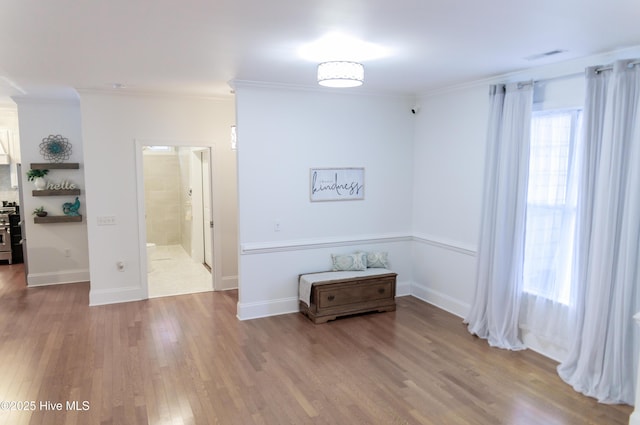 empty room with hardwood / wood-style flooring and crown molding