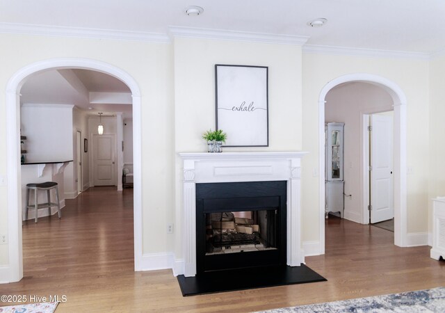 living room with hardwood / wood-style flooring, crown molding, and ceiling fan