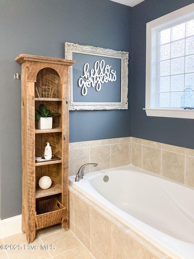 bathroom with a relaxing tiled tub and tile patterned floors