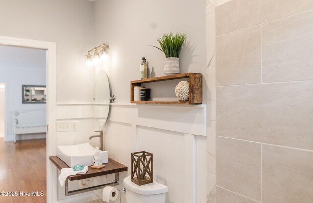 bathroom featuring a wealth of natural light, a tile shower, and toilet