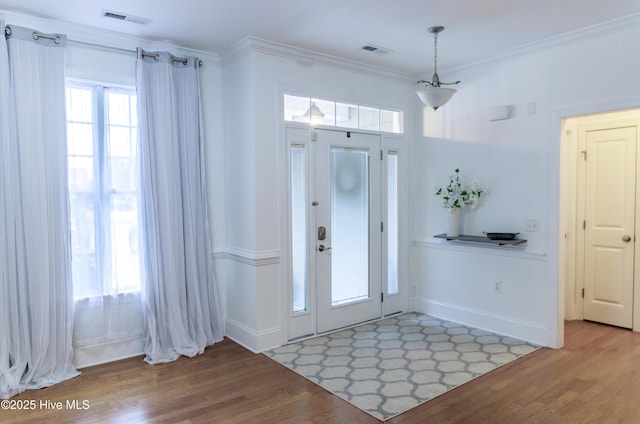 entryway with hardwood / wood-style floors and ornamental molding