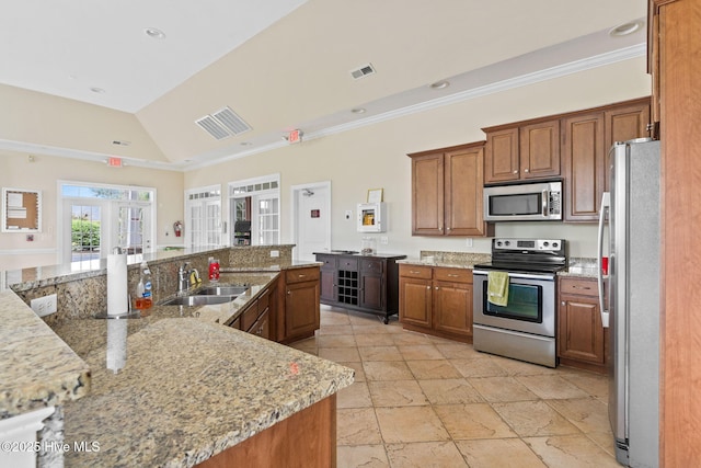 kitchen with light stone counters, stainless steel appliances, and sink