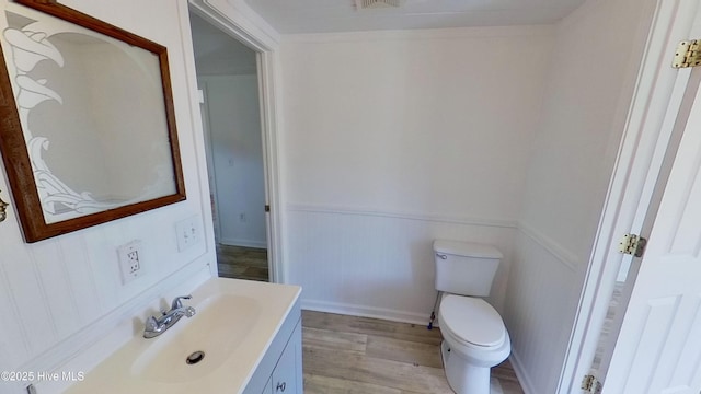 bathroom featuring vanity, hardwood / wood-style floors, and toilet