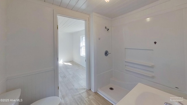 bathroom with hardwood / wood-style flooring, a shower, wooden ceiling, and toilet