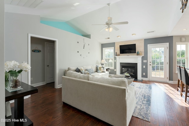 living room featuring lofted ceiling, dark wood-type flooring, and ceiling fan