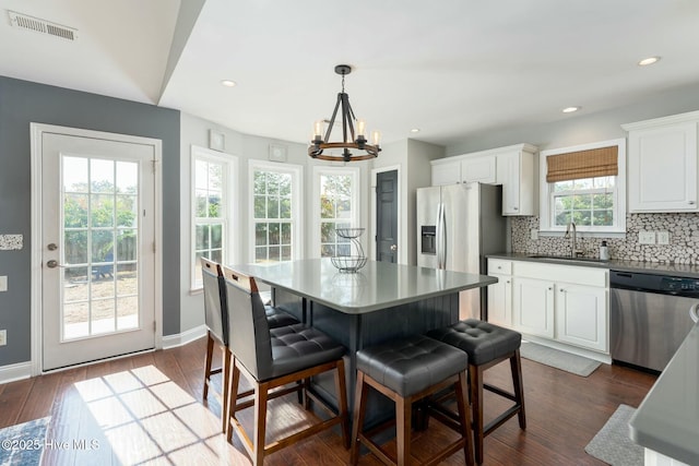 kitchen featuring hanging light fixtures, appliances with stainless steel finishes, sink, and white cabinets