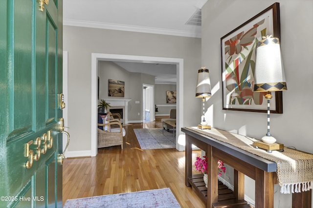 foyer featuring crown molding and light hardwood / wood-style flooring