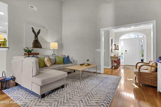 living room featuring light hardwood / wood-style floors and a high ceiling