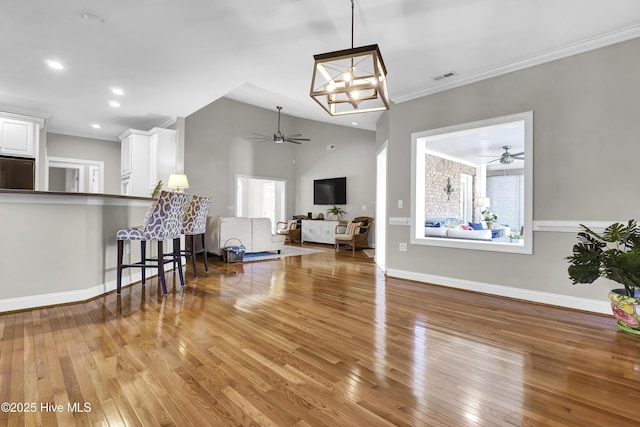 living room featuring crown molding, lofted ceiling, ceiling fan, and light hardwood / wood-style flooring