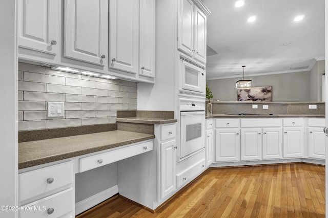 kitchen featuring hanging light fixtures, white cabinetry, and white appliances