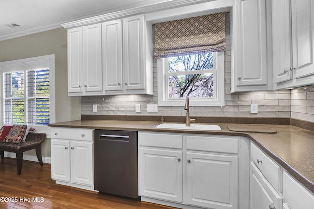 kitchen with sink, plenty of natural light, ornamental molding, dishwasher, and white cabinets