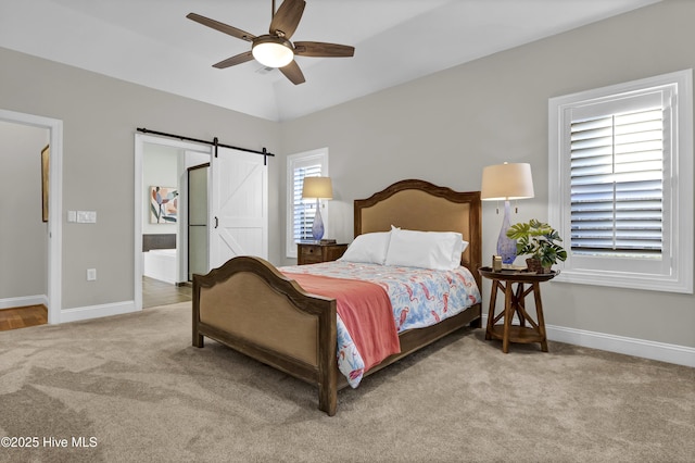 bedroom with a barn door, ceiling fan, and carpet flooring