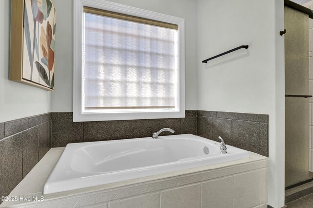 bathroom featuring independent shower and bath