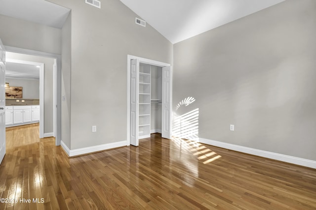 unfurnished room with lofted ceiling and hardwood / wood-style floors