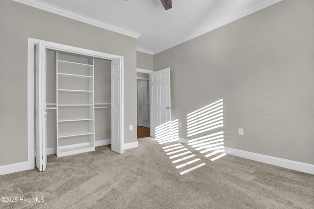 unfurnished bedroom featuring crown molding, light colored carpet, ceiling fan, and a closet