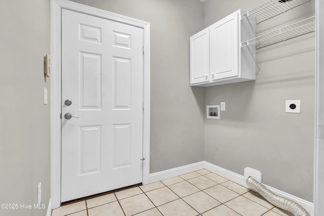 clothes washing area featuring cabinets, light tile patterned floors, hookup for a washing machine, and electric dryer hookup