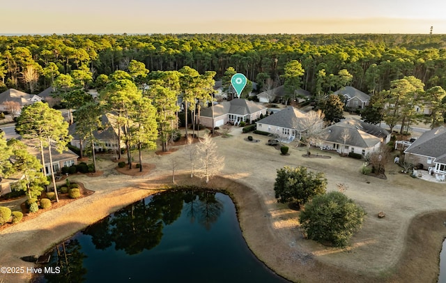 aerial view at dusk featuring a water view