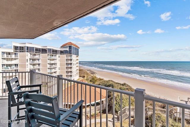 balcony with a water view and a beach view