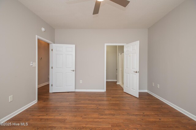 unfurnished bedroom featuring dark hardwood / wood-style floors and ceiling fan