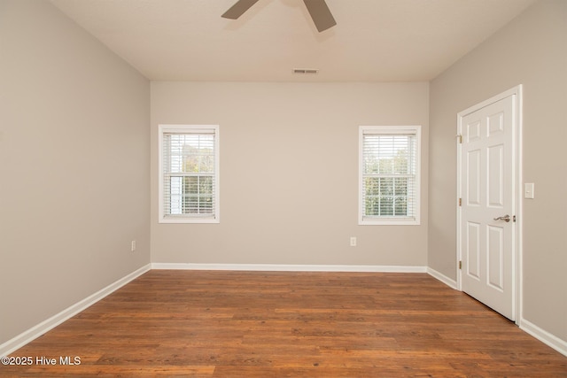 spare room featuring plenty of natural light, dark hardwood / wood-style floors, and ceiling fan