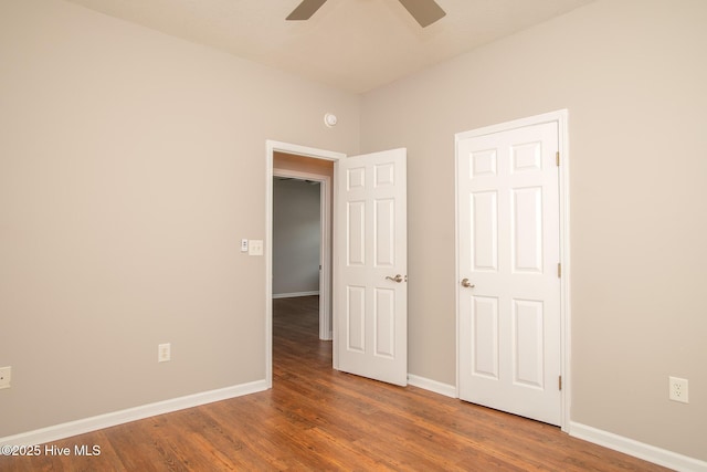 unfurnished bedroom featuring ceiling fan and dark hardwood / wood-style flooring