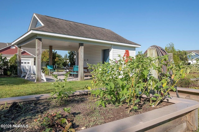 exterior space featuring an outbuilding, a garage, and a lawn