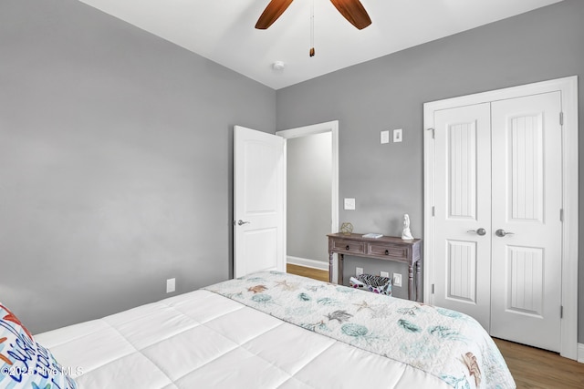 bedroom with hardwood / wood-style floors, a closet, and ceiling fan