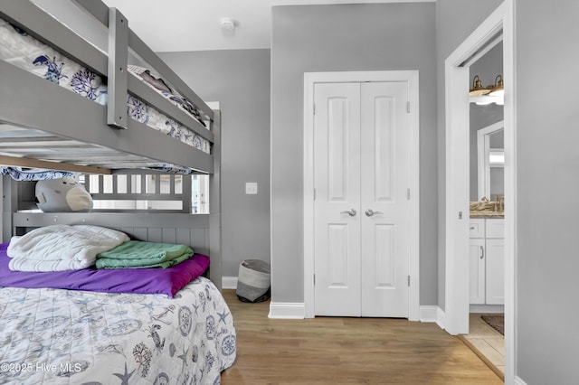 bedroom with light hardwood / wood-style floors and a closet