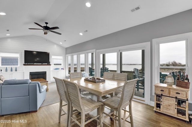 dining room featuring ceiling fan, lofted ceiling, and light wood-type flooring