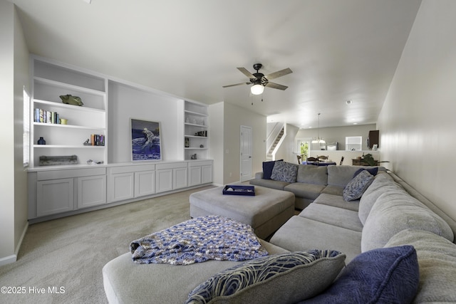 living room featuring light colored carpet, built in features, and ceiling fan