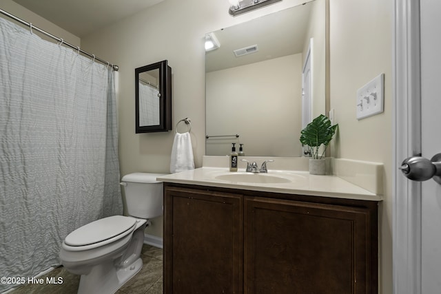 bathroom with tile patterned flooring, vanity, and toilet