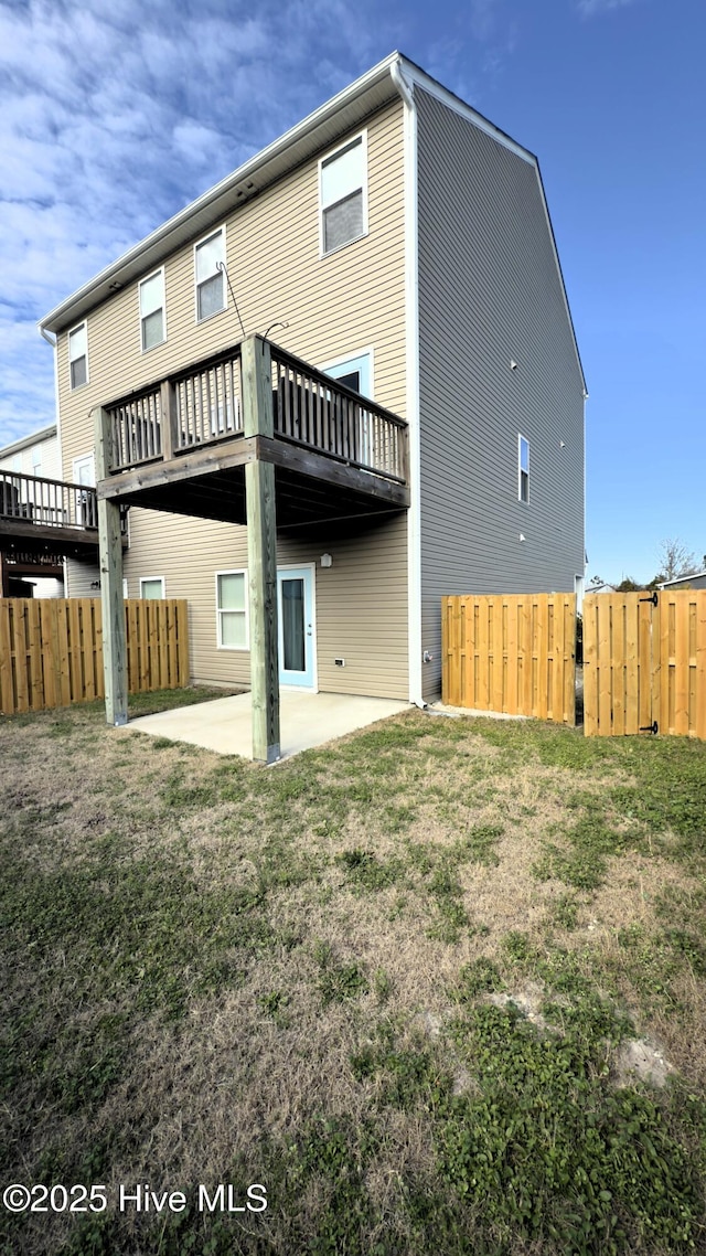 back of house featuring a yard, a deck, and a patio area