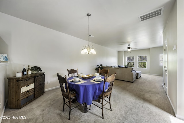 carpeted dining room with ceiling fan