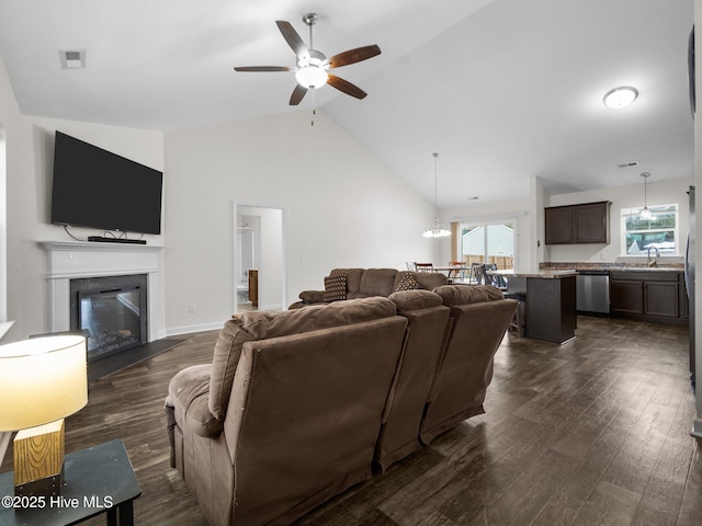 living room with high vaulted ceiling, dark wood-type flooring, sink, and ceiling fan