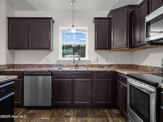 kitchen with sink, dark brown cabinets, hanging light fixtures, appliances with stainless steel finishes, and dark hardwood / wood-style flooring