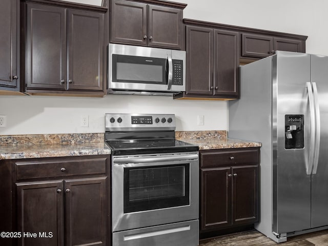 kitchen with stone counters, appliances with stainless steel finishes, dark brown cabinets, and dark hardwood / wood-style floors